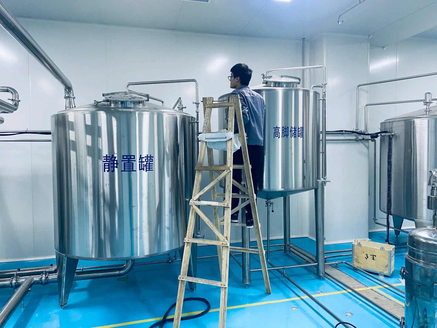 工作人員正在檢查飲料廠靜置罐 工作人員正在檢查飲料廠靜置罐